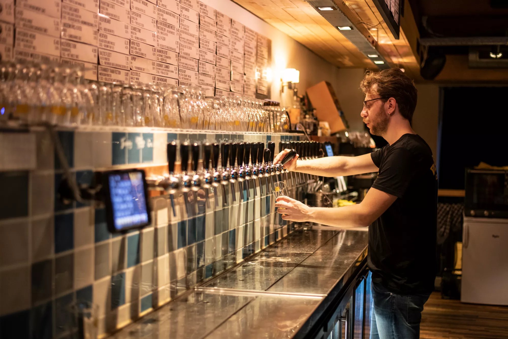 Een man tapt bier in aan een Van Moll tap